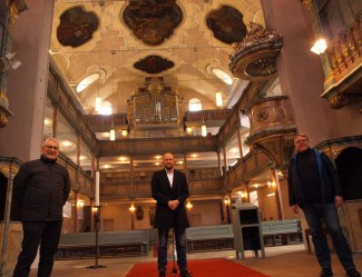 Dietrich Kappler vom Hersbrucker Kirchbauverein, Dekan Tobias Schäfer und Pfarrer Thomas Lichteneber halten die Kunst in der Stadtkirche hoch.