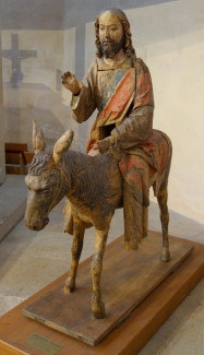 Auf einer Eselin sitzend, mit zum Segen erhobener Hand, damit ähnelt der Hersbrucker Palmesel allen erhaltenen Varianten